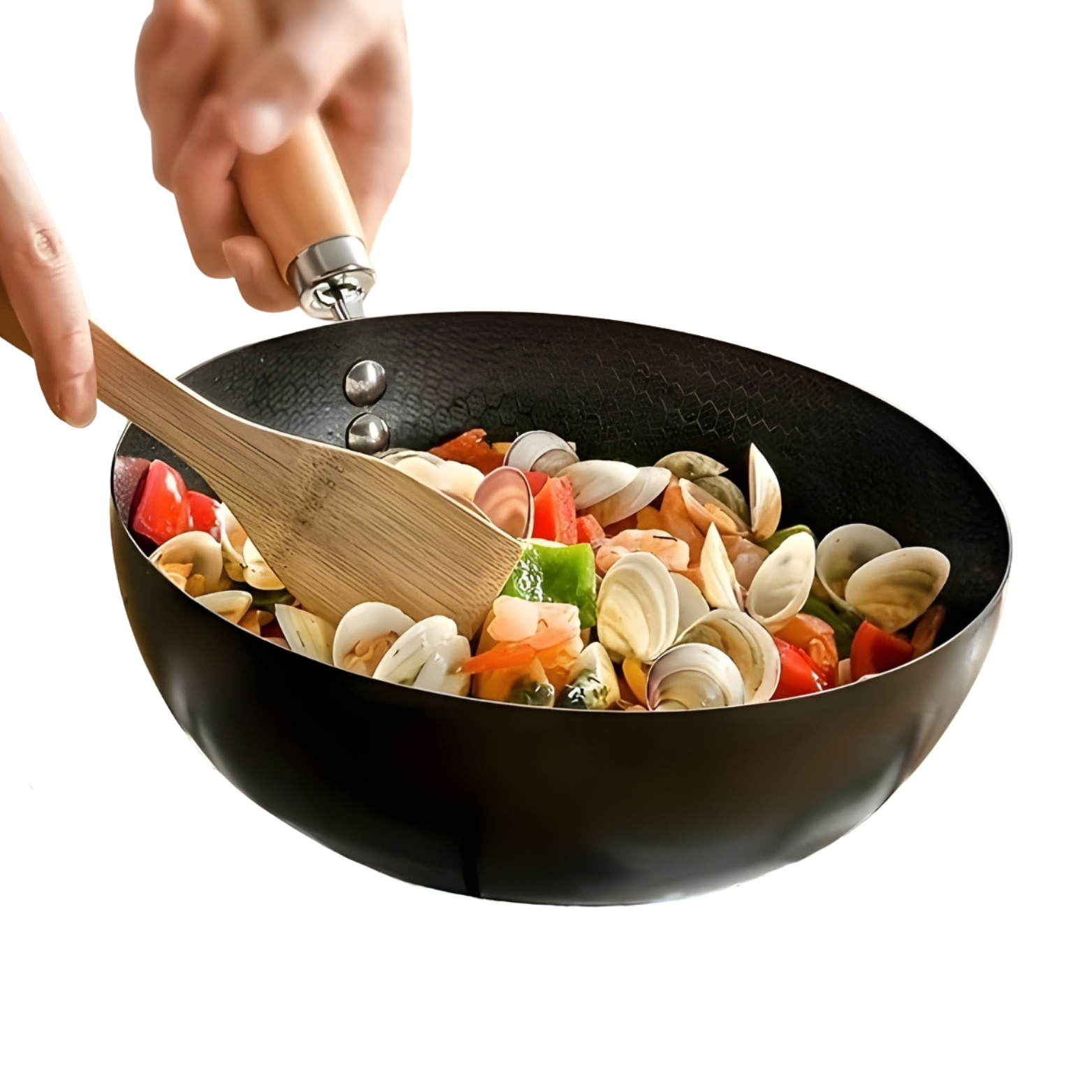 Black wok with vegetables being stirred with a wooden spoon on a white background