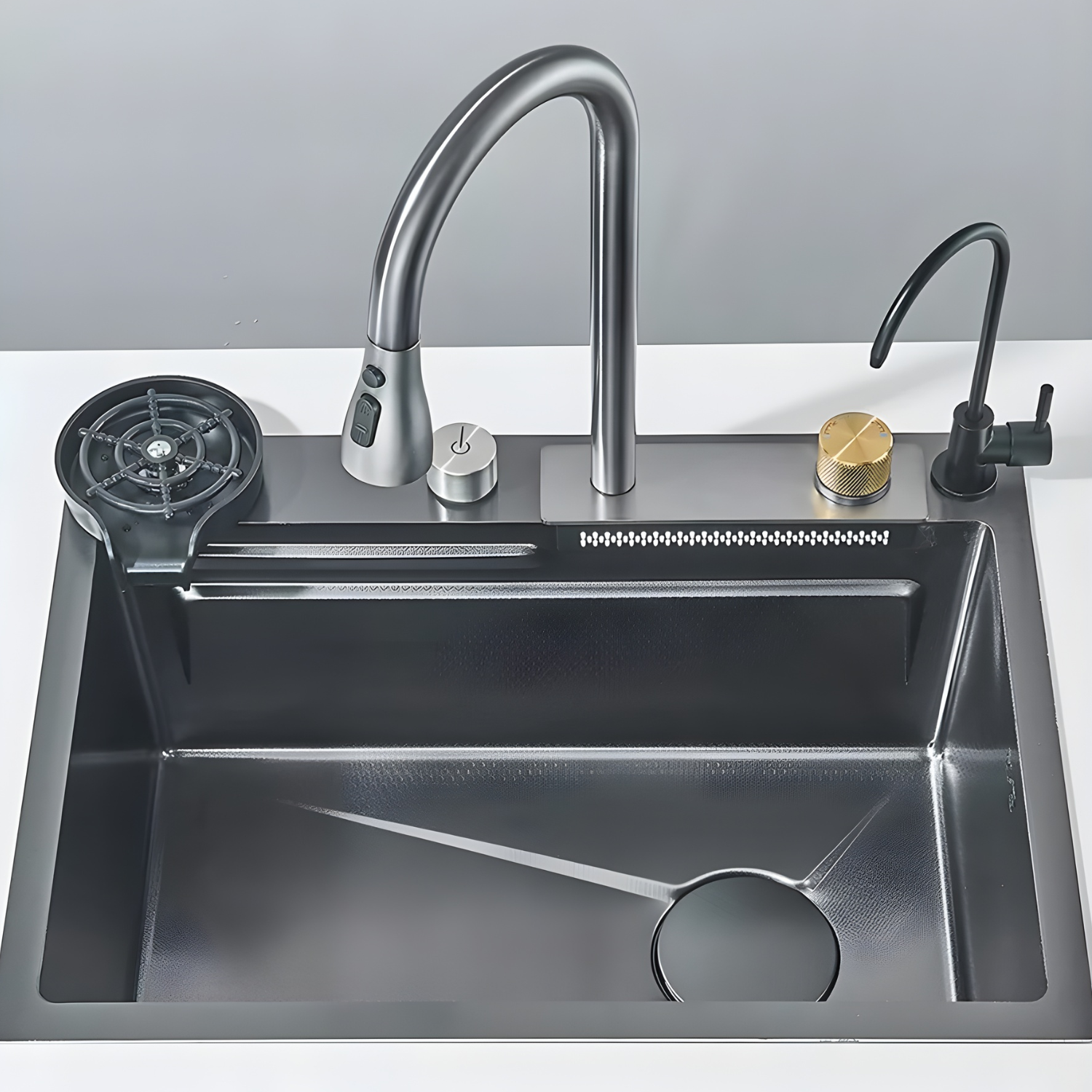 Stainless steel kitchen sink with faucet and accessories on a white countertop.